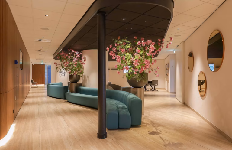 Drie spiegels, blauwe bank en sierbloemen
